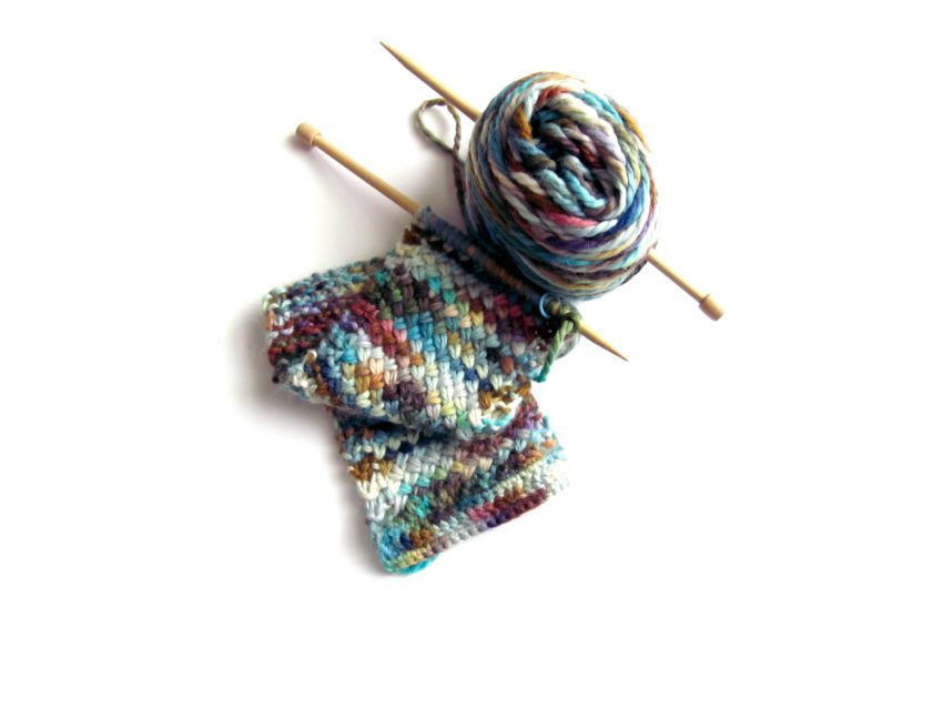 A multi-colored cross stitch scarf in progress.