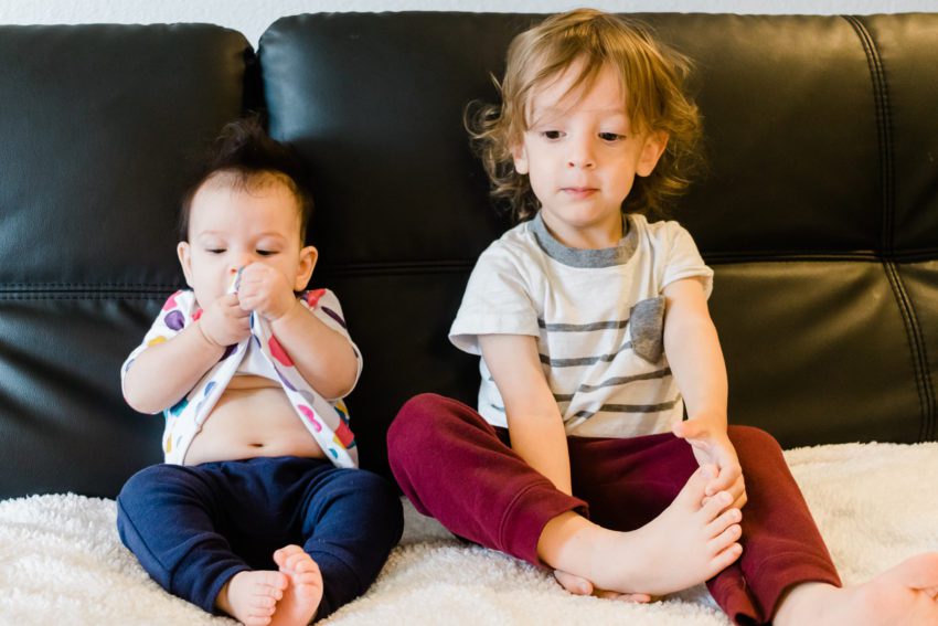 Baby eating dress, toddler looking unimpressed
